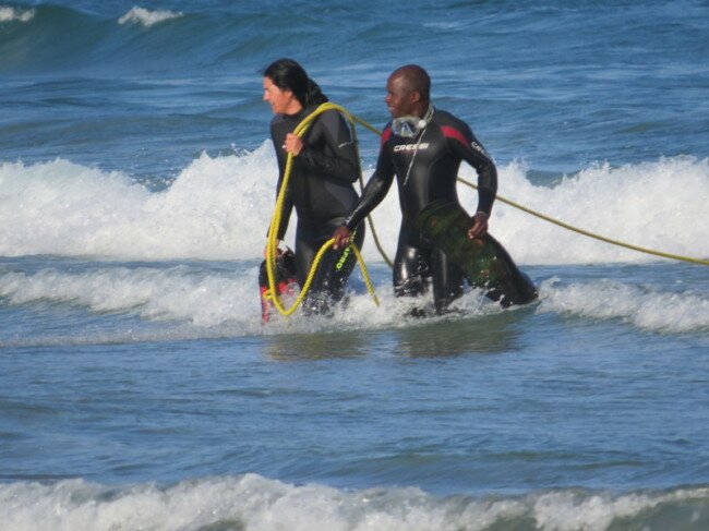 Crew members from Shark Explorer bringing in the towing rope attached to the whale. Photo: Viv of Scenic South